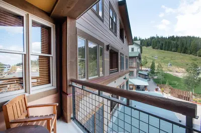 a balcony with a chair and a view of a mountain at Stunning Zephyr Mountain Lodge Condo Overlooking The Village Plaza condo in Winter Park