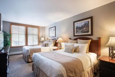 a hotel room with two beds and two windows at Lovely Zephyr Mountain Lodge Condo with Mountain Slope Views condo in Winter Park