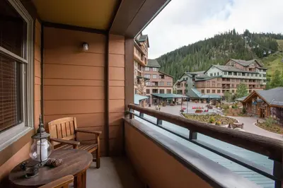 a balcony with a table and a view of a town at Lovely Zephyr Mountain Lodge Condo with Mountain Slope Views condo in Winter Park