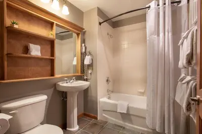 a bathroom with a toilet and a sink and a tub at Lovely Zephyr Mountain Lodge Condo with Mountain Slope Views condo in Winter Park