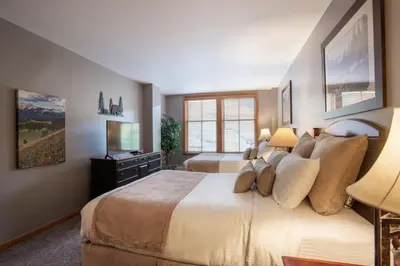 a large bedroom with two beds and a television at Lovely Zephyr Mountain Lodge Condo with Mountain Slope Views condo in Winter Park