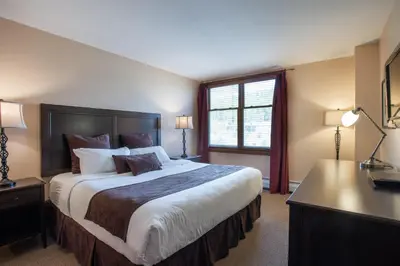 a large bedroom with a large bed and a desk at Lovely Zephyr Mountain Lodge condo with Continental Divide and Village Views condo in Winter Park
