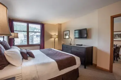 a hotel room with a bed and a television at Lovely Zephyr Mountain Lodge condo with Continental Divide and Village Views condo in Winter Park