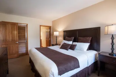 a bedroom with a large bed with a wooden headboard at Lovely Zephyr Mountain Lodge condo with Continental Divide and Village Views condo in Winter Park