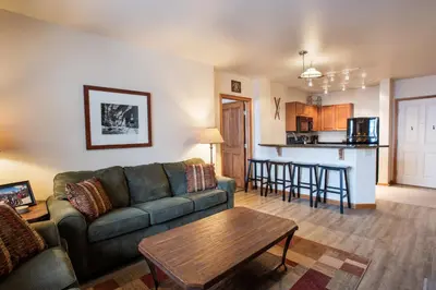 a living room and kitchen with a couch and a table at Terrific Zephyr Mountain Lodge Condo With Beautiful Views of the Continental Divide near Mountain condo in Winter Park