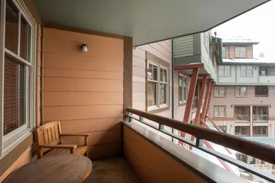 a balcony with a wooden table and a chair at Terrific Zephyr Mountain Lodge Condo With Beautiful Views of the Continental Divide near Mountain condo in Winter Park