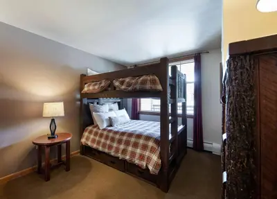 a bedroom with a bunk bed and a table at Terrific Zephyr Mountain Lodge Condo With Beautiful Views of the Continental Divide near Mountain condo in Winter Park