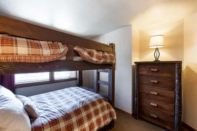 a bedroom with a bunk bed and a dresser at Terrific Zephyr Mountain Lodge Condo With Beautiful Views of the Continental Divide near Mountain condo in Winter Park