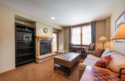 a living room with a couch and a fireplace at Large Zephyr Mountain Lodge condo with fireplace and Village Views condo in Winter Park
