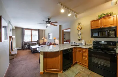 a kitchen with a counter and a living room at Large Zephyr Mountain Lodge condo with fireplace and Village Views condo in Winter Park