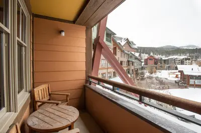 a balcony with a chair and a view of a town at Large Zephyr Mountain Lodge condo with fireplace and Village Views condo in Winter Park