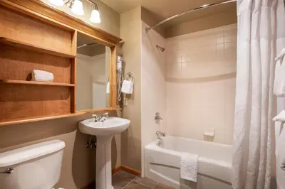 a bathroom with a sink and a toilet and a tub at Large Zephyr Mountain Lodge condo with fireplace and Village Views condo in Winter Park