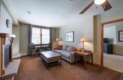 a living room with a couch and a tv at Large Zephyr Mountain Lodge condo with fireplace and Village Views condo in Winter Park