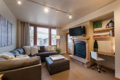 a living room with a couch and a fireplace at Great Zephyr Mountain Lodge Condo with Village & Continental Divide Views condo in Winter Park