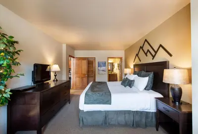 a bedroom with a large bed and a television at Great Zephyr Mountain Lodge Condo with Village & Continental Divide Views condo in Winter Park