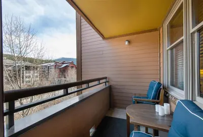 a balcony with a table and chairs and a window at Great Zephyr Mountain Lodge Condo with Village & Continental Divide Views condo in Winter Park