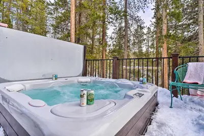 a jacuzzi tub in the snow with a chair at Grand Fraser Escape with Private Deck and Hot Tub in Fraser