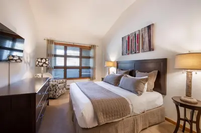 a bedroom with a bed and a dresser and a desk at Zephyr Mountain Lodge - Premium Rated Condo 1701 in Winter Park
