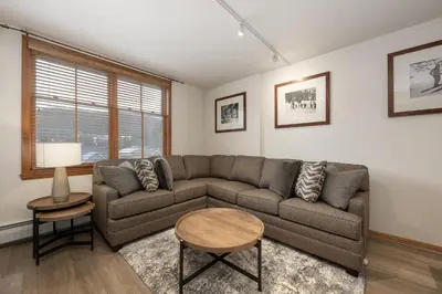 a living room with a couch and a table at Upgraded Zephyr Mountain Lodge Condo with Continental Divide Views Close to Mountain condo in Winter Park