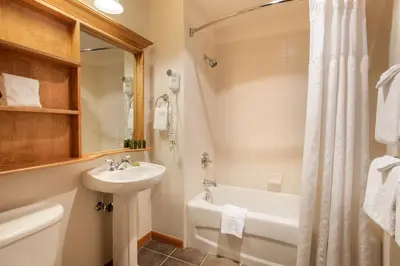 a bathroom with a sink and a toilet and a tub at Upgraded Zephyr Mountain Lodge Condo with Continental Divide Views Close to Mountain condo in Winter Park