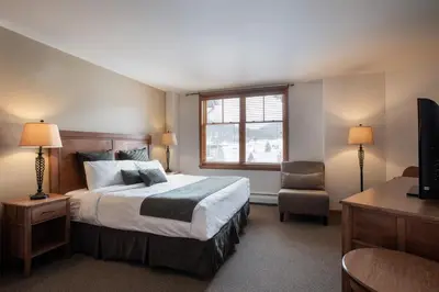 a bedroom with a bed and a chair and a window at Upgraded Zephyr Mountain Lodge Condo with Continental Divide Views Close to Mountain condo in Winter Park