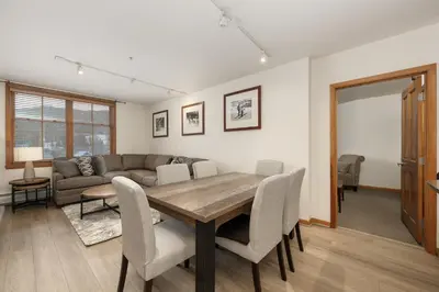 a living room with a table and chairs and a couch at Upgraded Zephyr Mountain Lodge Condo with Continental Divide Views Close to Mountain condo in Winter Park