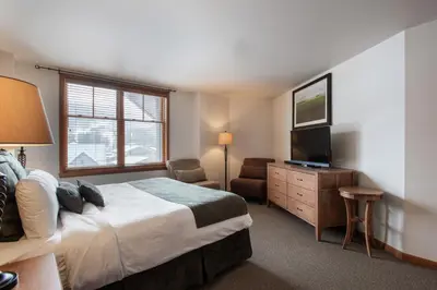 a hotel room with a bed and a television at Upgraded Zephyr Mountain Lodge Condo with Continental Divide Views Close to Mountain condo in Winter Park