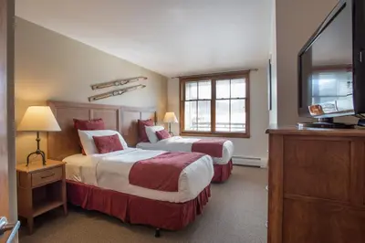 a hotel room with two beds and a flat screen tv at Upgraded Zephyr Mountain Lodge Condo with Continental Divide Views Close to Mountain condo in Winter Park