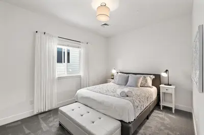 a white bedroom with a bed and a window at Steps from River & Old Town - Hot Tub & King Bed in Fort Collins