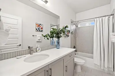 a white bathroom with a sink and a toilet at Steps from River & Old Town - Hot Tub & King Bed in Fort Collins
