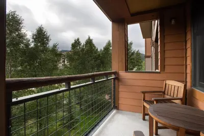 a balcony with a table and a chair and a window at Zephyr Mountain Lodge Value-Rated 2202 in Winter Park