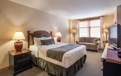 a bedroom with a large bed and a chair at Zephyr Mountain Lodge Value-Rated 2202 in Winter Park