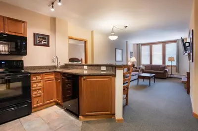 a kitchen with a counter and a living room at Zephyr Mountain Lodge Value-Rated 2202 in Winter Park
