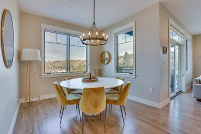 a dining room with a table and chairs and windows at Winter Park Condo with Balcony about 4 Mi to Slopes in Winter Park