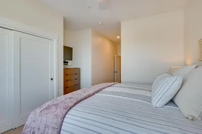 a bedroom with a large bed with white walls at Winter Park Condo with Balcony about 4 Mi to Slopes in Winter Park