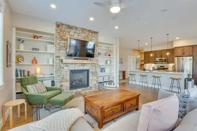 a living room with a fireplace and a tv at Winter Park Condo with Balcony about 4 Mi to Slopes in Winter Park