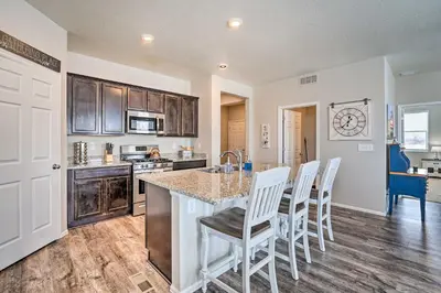 a kitchen with wooden cabinets and a table and chairs at Dreamy Windsor Home with Grill about 3 Miles to Lake! in Windsor