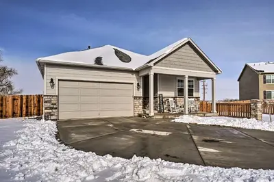 a house with a garage in the snow at Dreamy Windsor Home with Grill about 3 Miles to Lake! in Windsor