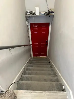 a staircase with a red door and a red cabinet at Basement Unit 2br 2ba in Barnum West Near Belmar and Sloan Lake 10 mins to Downtown in Denver