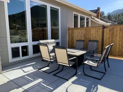 a patio with a table and chairs on a deck at The Getaway,Hot Tub, AC, 2miles from RMNP in Estes Park