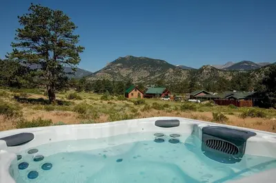 a bath tub in a field with mountains in the background at The Getaway,Hot Tub, AC, 2miles from RMNP in Estes Park