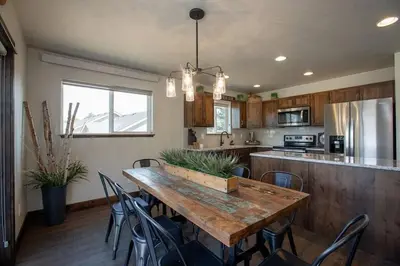 a kitchen with a large wooden table and chairs at The Getaway,Hot Tub, AC, 2miles from RMNP in Estes Park