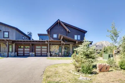a large wooden house with mountains in the background at Hike, Ski, Golf, and Fish Silverthorne Townhome! in Silverthorne