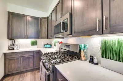 a kitchen with wooden cabinets and a stove top oven at Hike, Ski, Golf, and Fish Silverthorne Townhome! in Silverthorne