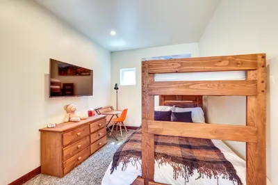 a bedroom with a wooden bunk bed and a desk at Hike, Ski, Golf, and Fish Silverthorne Townhome! in Silverthorne