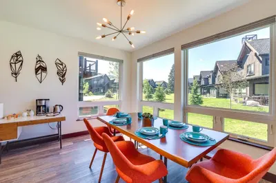 a dining room with a table and chairs and windows at Hike, Ski, Golf, and Fish Silverthorne Townhome! in Silverthorne