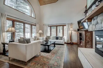 a living room with a white couch and a fireplace at Sunset Cabin - Creekside by Ski Country Resorts in Frisco