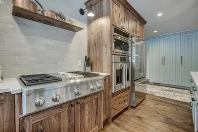 a kitchen with wooden cabinets and a stove at Sunset Cabin - Creekside by Ski Country Resorts in Frisco