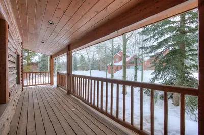 a wooden porch with a view of a house at Sunset Cabin - Creekside by Ski Country Resorts in Frisco