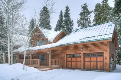 a log cabin with snow on the roof at Sunset Cabin - Creekside by Ski Country Resorts in Frisco